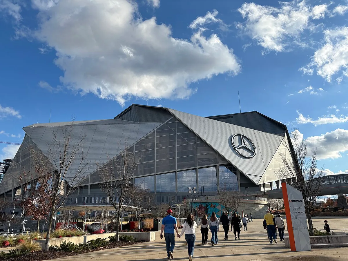Fans walking toward Mercedes-Benz Stadium on a clear day in Atlanta